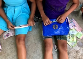 En Venezuela, niños juegan con los billetes en desuso luego de la segunda reconversión en dos años