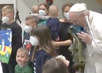El Papa Francisco besa una bandera de Ucrania, traída desde la ciudad de Bucha, y entregada por un grupo de niños ucranianos.