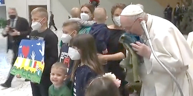 El Papa Francisco besa una bandera de Ucrania, traída desde la ciudad de Bucha, y entregada por un grupo de niños ucranianos.