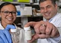 Amanda Nash y Omid Veiseh, muestran sus perlas de medicamento contra el cáncer. Foto cortesía Jeff Fitlow, Universidad Rice.