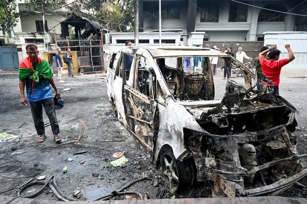 Se ve un automóvil quemado frente a la oficina del partido Liga Awami mientras los manifestantes antigubernamentales prenden fuego en Dhaka